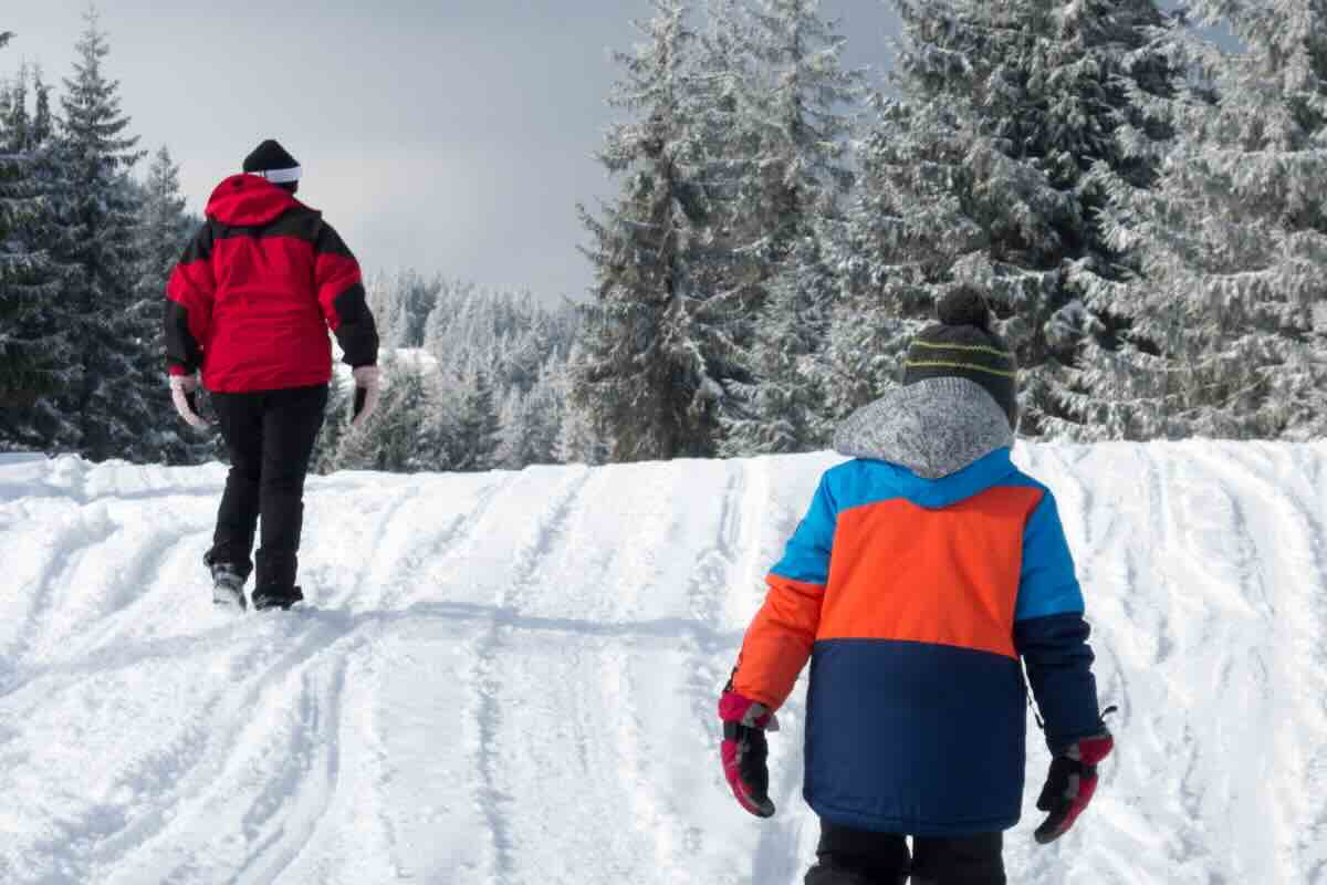 bambino e adulto sulla neve